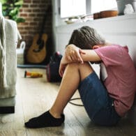 Fotografía de niño triste sentado en el suelo